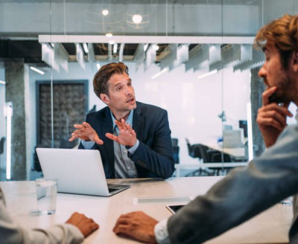 Shot of young couple having a consultation with a financial advisor in the office. Group of business persons in business meeting. Three entrepreneurs on meeting in board room. Corporate business team on meeting in modern office. Male manager discussing new project with his colleagues. Company owner on a meeting with two of his employees in his office.